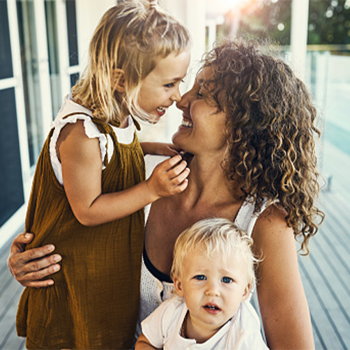 Femme avec ses deux enfants dans les bras