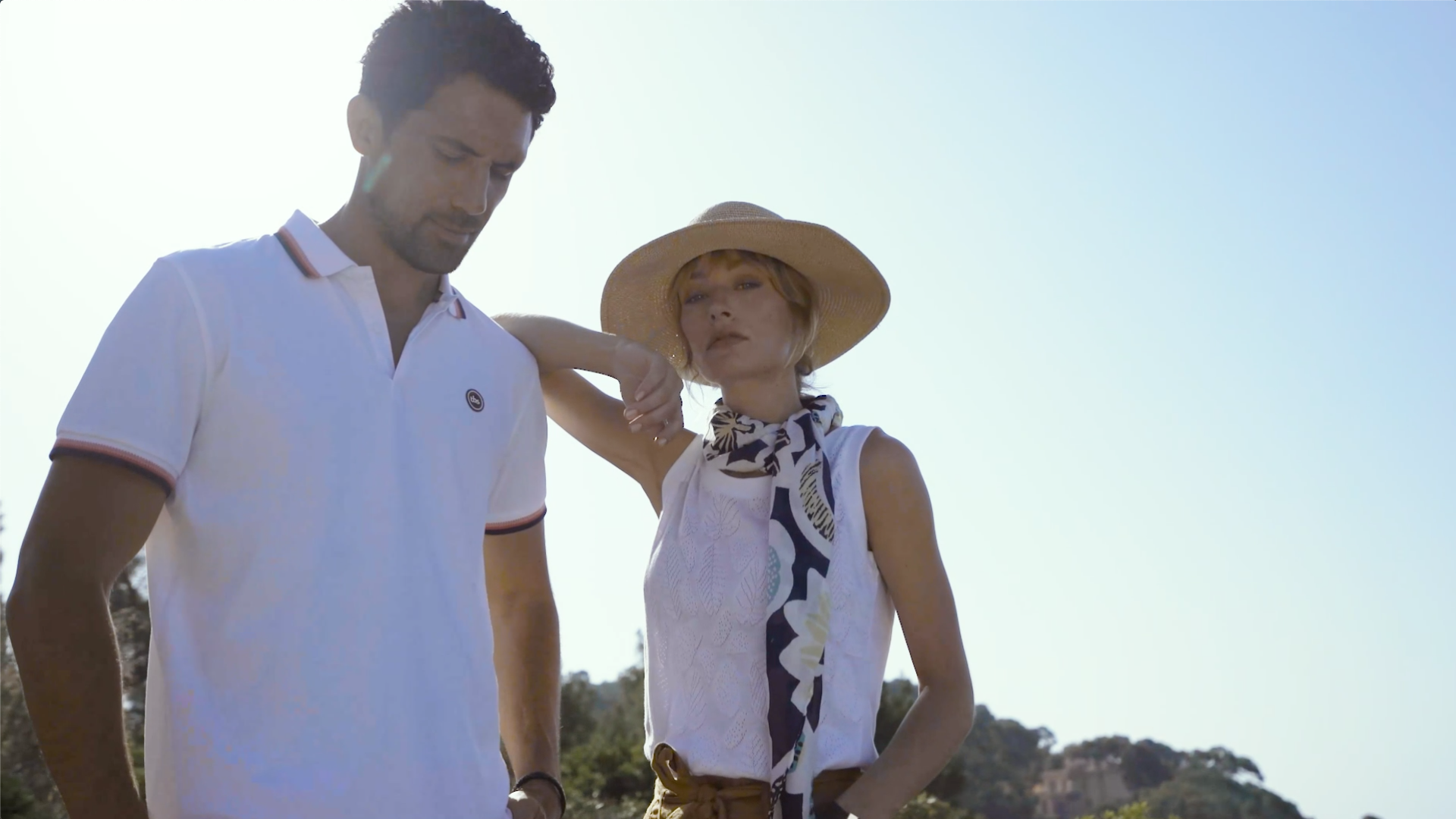 Homme et femme habillés en blanc posant au soleil